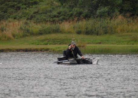 Jim Burtle playing a fish while Float Tubing